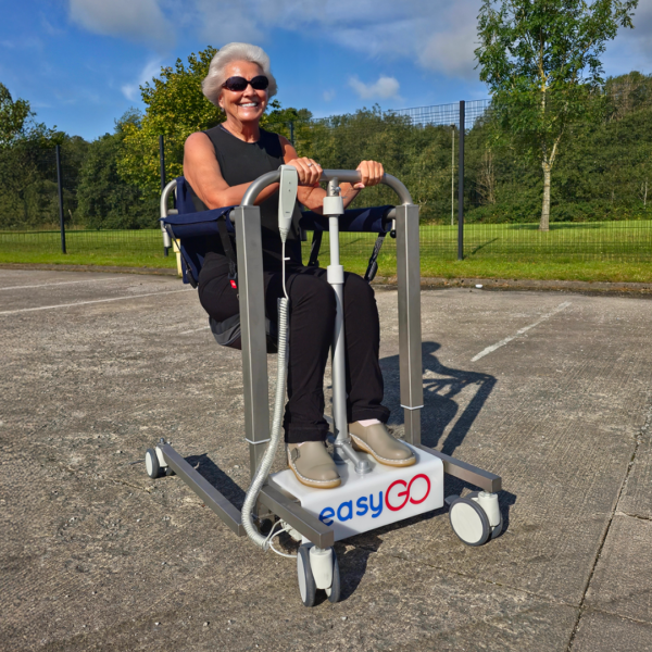 a woman using a patient lift and transfer chair outside